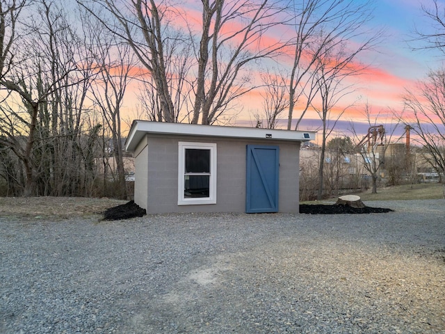 outdoor structure at dusk featuring an outdoor structure and a shed