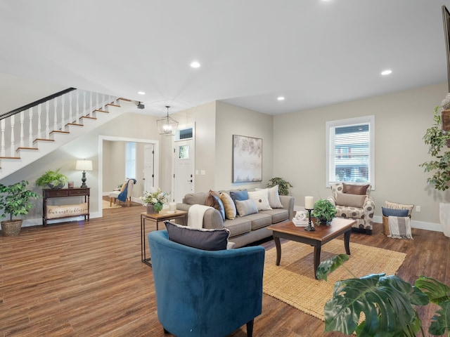 living area with recessed lighting, baseboards, dark wood finished floors, and stairs