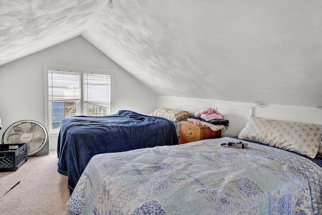 bedroom with vaulted ceiling, a textured ceiling, and carpet floors