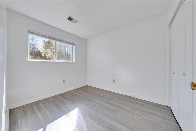 unfurnished bedroom with visible vents, baseboards, a closet, and light wood-style flooring