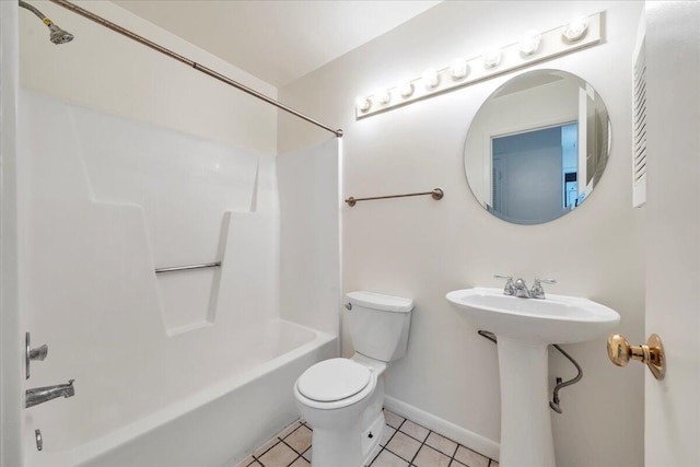 bathroom with tile patterned floors, baseboards, toilet, and washtub / shower combination