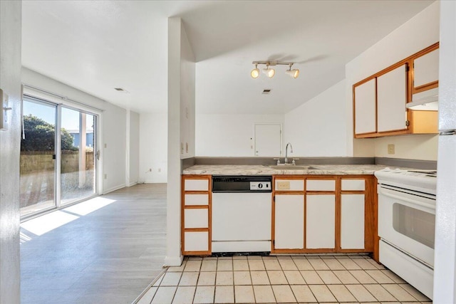 kitchen featuring a sink, white appliances, under cabinet range hood, and light countertops