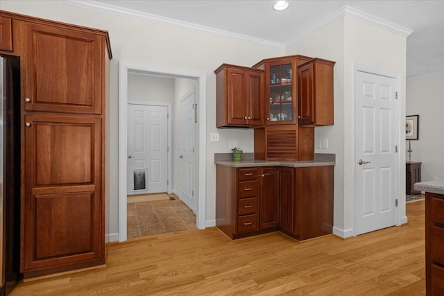 kitchen with crown molding, glass insert cabinets, light wood-type flooring, and baseboards