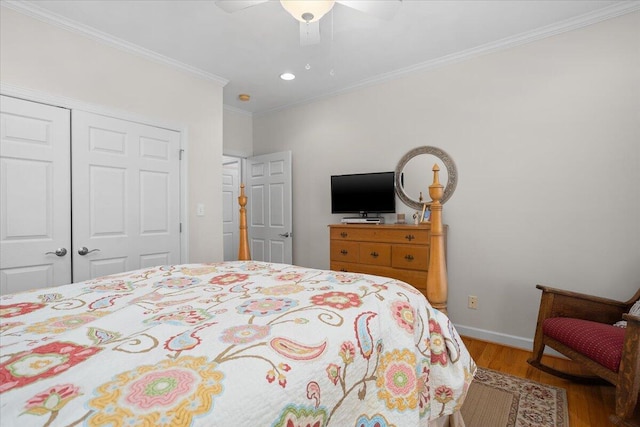 bedroom featuring crown molding, baseboards, wood finished floors, a closet, and a ceiling fan