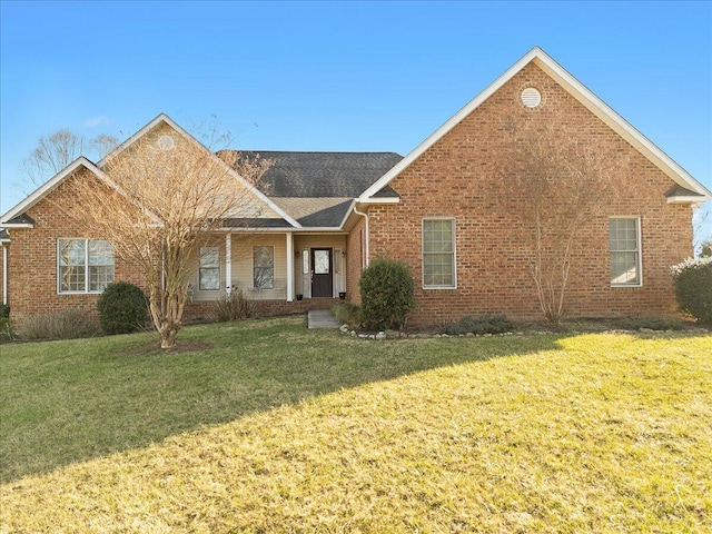 ranch-style house featuring brick siding, roof with shingles, and a front yard