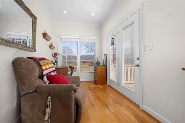 living area featuring light wood finished floors, recessed lighting, crown molding, and baseboards