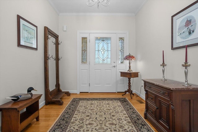 entrance foyer with crown molding, baseboards, and light wood finished floors