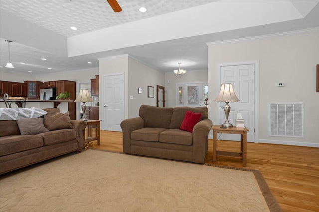 living area with visible vents, light wood finished floors, baseboards, recessed lighting, and ceiling fan with notable chandelier