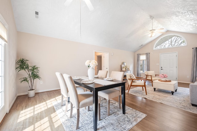 dining space featuring vaulted ceiling, wood finished floors, visible vents, and ceiling fan