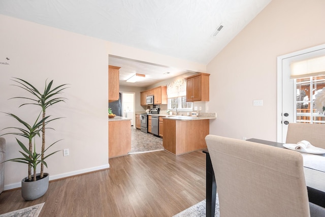 dining area with light wood finished floors, visible vents, baseboards, and lofted ceiling