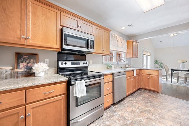 kitchen with visible vents, lofted ceiling, appliances with stainless steel finishes, a peninsula, and a sink