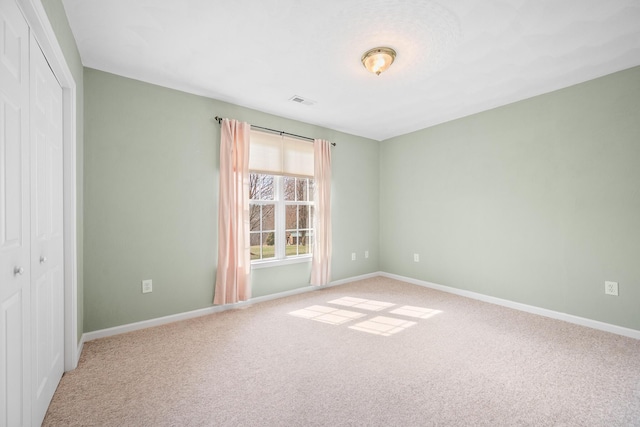 carpeted spare room featuring baseboards