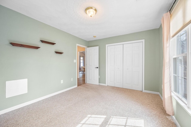 unfurnished bedroom with carpet flooring, baseboards, and a closet