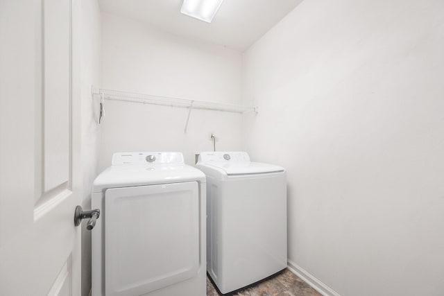 washroom featuring baseboards, washing machine and dryer, and laundry area