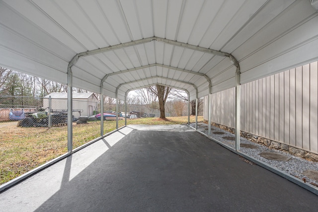 view of parking / parking lot with a detached carport and fence