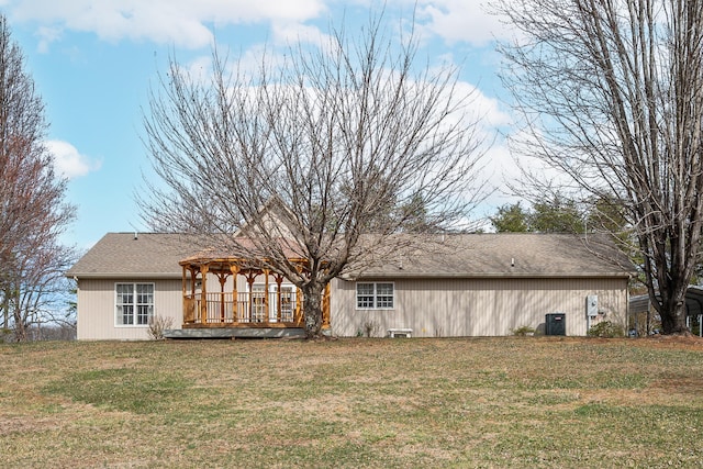 rear view of property with central AC unit, a yard, a pergola, a shingled roof, and a deck