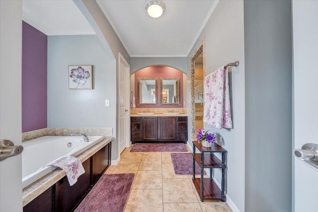 bathroom with tile patterned floors, a garden tub, ornamental molding, baseboards, and vanity