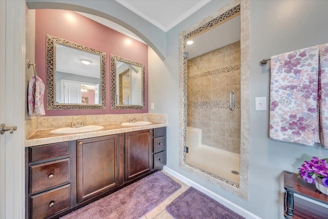 full bathroom featuring tile patterned floors, a stall shower, ornamental molding, a sink, and double vanity