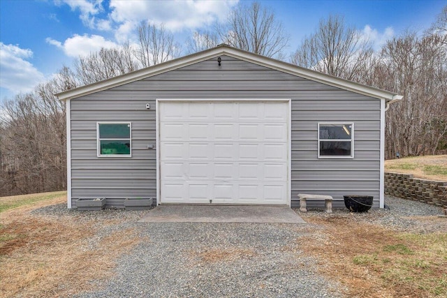 detached garage featuring gravel driveway