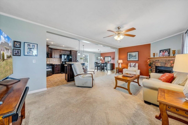 living area with light colored carpet, a fireplace, ceiling fan, and ornamental molding