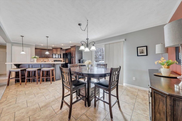 dining area featuring baseboards, a textured ceiling, ornamental molding, and light tile patterned flooring