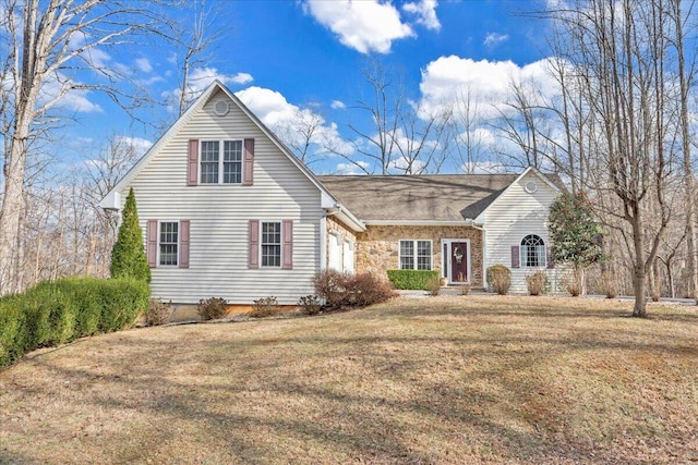 view of front of property featuring stone siding, an attached garage, and a front yard