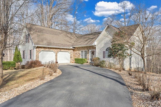 view of front of house featuring aphalt driveway, stone siding, an attached garage, and a shingled roof