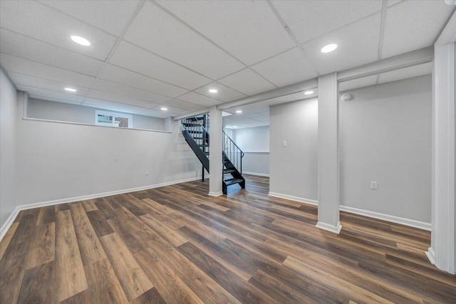 finished below grade area featuring stairs, recessed lighting, wood finished floors, and baseboards