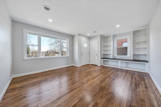 unfurnished living room with visible vents, built in features, wood finished floors, recessed lighting, and baseboards