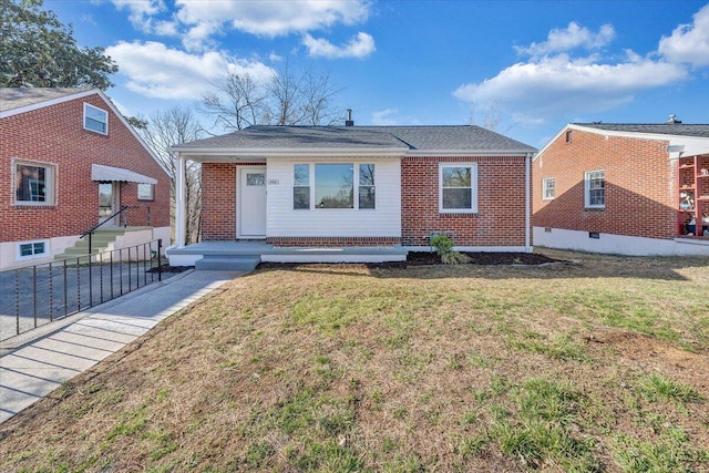 bungalow featuring a front yard and brick siding