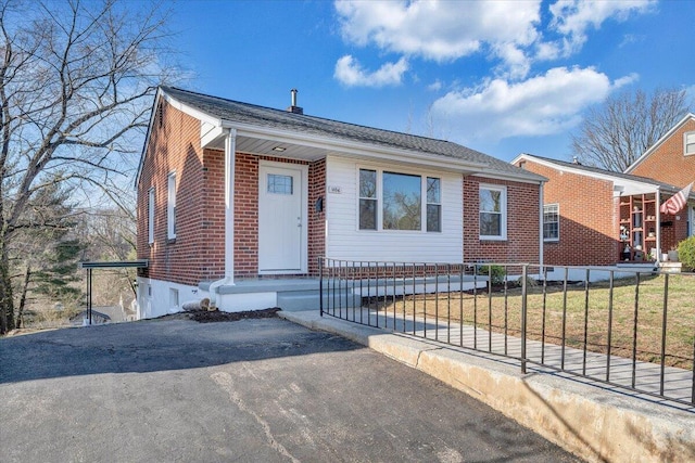 view of front facade featuring brick siding and a fenced front yard