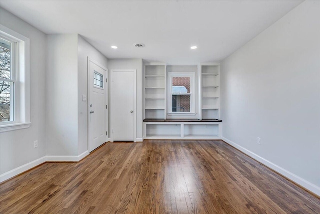 unfurnished living room featuring recessed lighting, baseboards, and wood finished floors