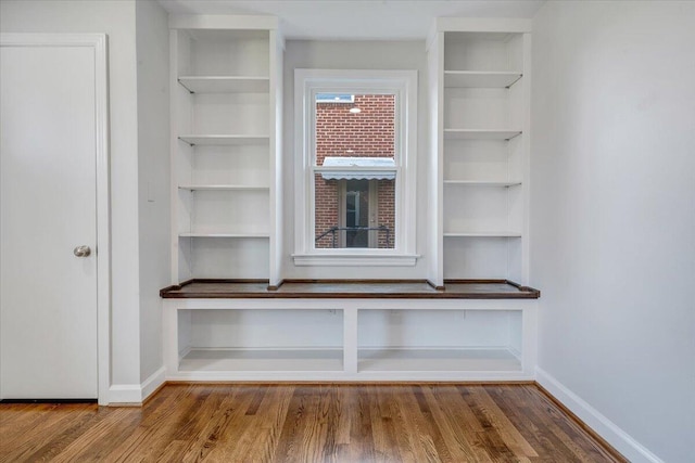 interior details featuring built in shelves, baseboards, and wood finished floors