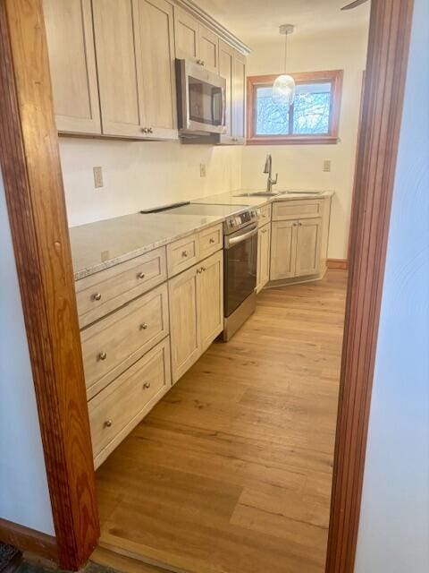 182 Dogwood Ln, Troutville, VA 24175 - kitchen featuring baseboards, light wood finished floors, a sink, stainless steel appliances, and decorative light fixtures