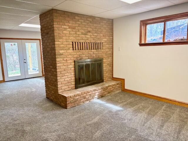 182 Dogwood Ln, Troutville, VA 24175 - unfurnished living room with carpet, baseboards, french doors, a paneled ceiling, and a brick fireplace