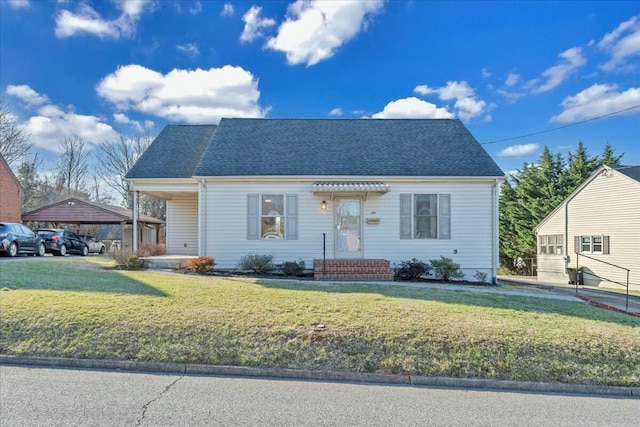 view of front of home with roof with shingles and a front yard