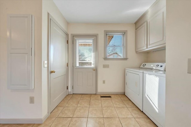 laundry area with cabinet space, light tile patterned floors, separate washer and dryer, and baseboards