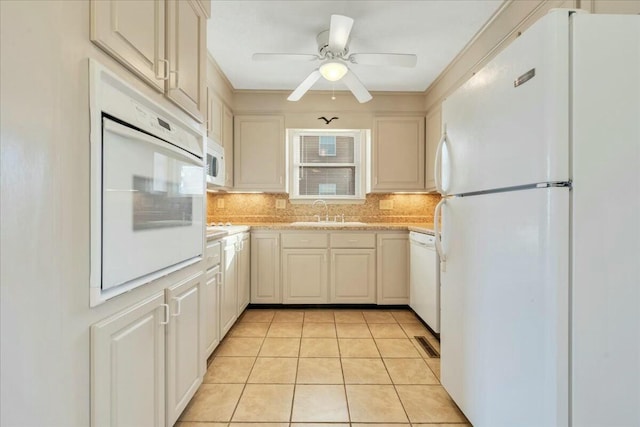 kitchen with light countertops, decorative backsplash, light tile patterned flooring, white appliances, and a sink