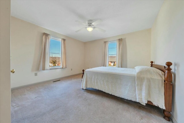 carpeted bedroom with visible vents, baseboards, and ceiling fan