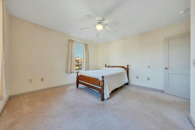 bedroom featuring light carpet, ceiling fan, and baseboards