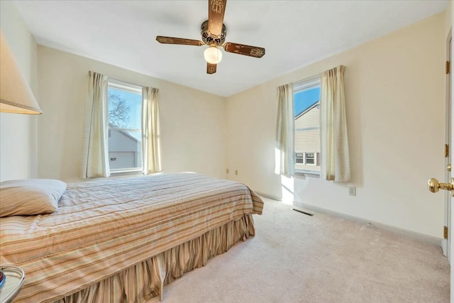 carpeted bedroom featuring visible vents, ceiling fan, and baseboards