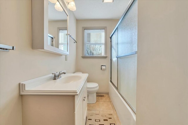 bathroom with tile patterned flooring, toilet, vanity, and shower / bath combination with glass door