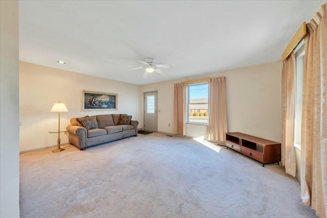 living area featuring carpet flooring and a ceiling fan