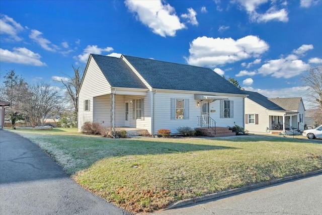 view of front facade featuring a front lawn and a shingled roof