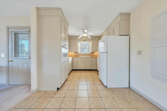 kitchen featuring backsplash, white appliances, light countertops, light tile patterned floors, and ceiling fan