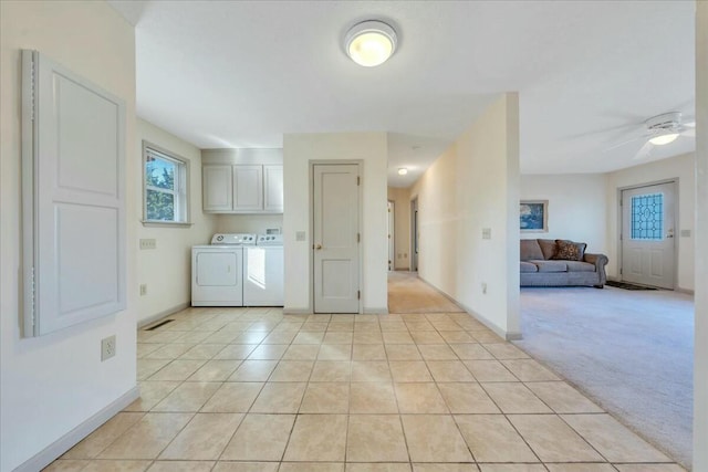 laundry room with washer and dryer, light tile patterned floors, baseboards, light colored carpet, and ceiling fan