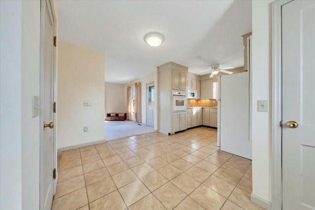 kitchen with backsplash, light tile patterned flooring, cream cabinetry, white appliances, and a ceiling fan