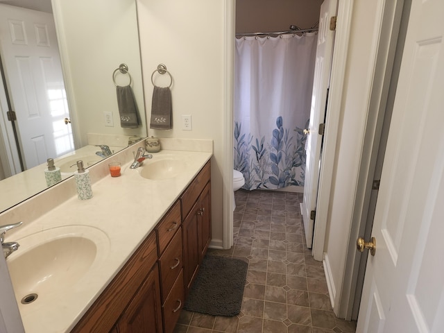 full bathroom featuring curtained shower, double vanity, toilet, and a sink