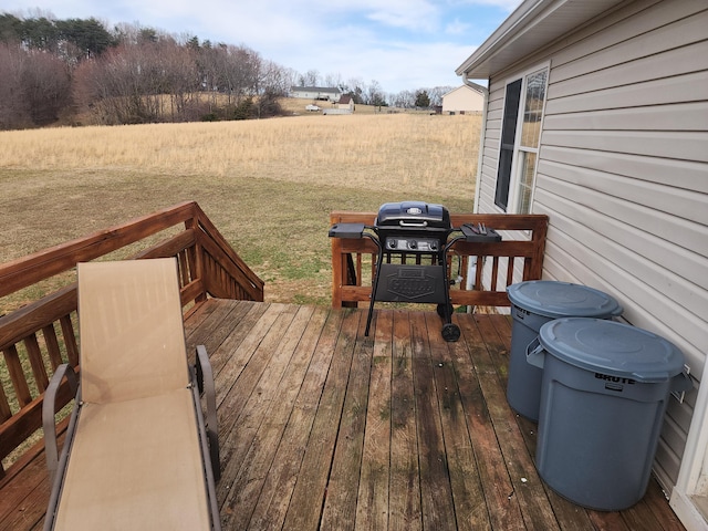 wooden deck with a yard and a grill