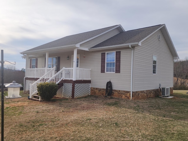 view of front of home with a porch, roof with shingles, central AC unit, and a front lawn